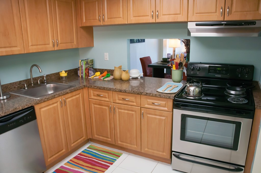 A kitchen with wooden cabinets and a black stove top oven.