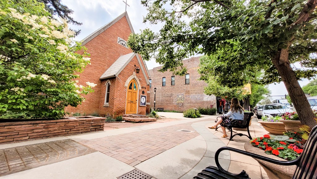 a woman sitting on a bench in front of a church