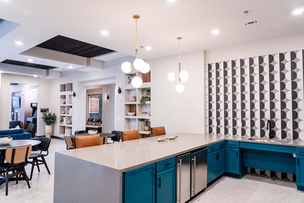 a large kitchen with blue cabinets and a table with chairs