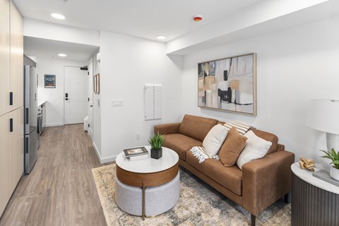 A living room with a brown couch and a coffee table.