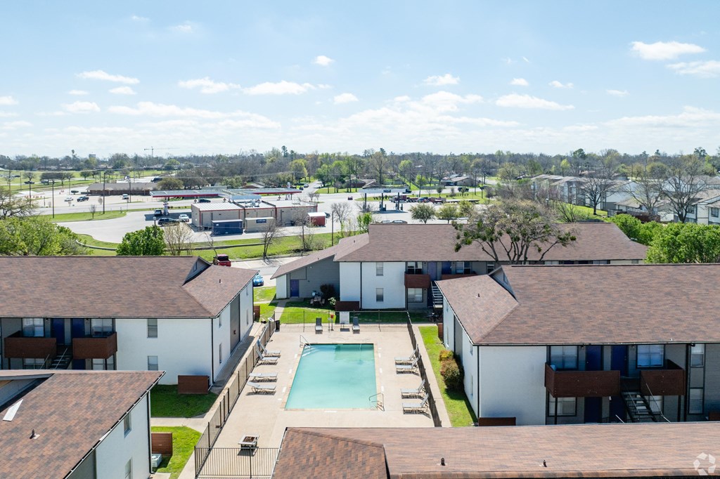 A view of apartment buildings with a pool in the foreground.