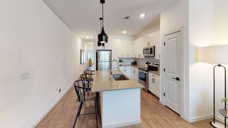 a kitchen with white cabinetry and a large center island with a breakfast bar