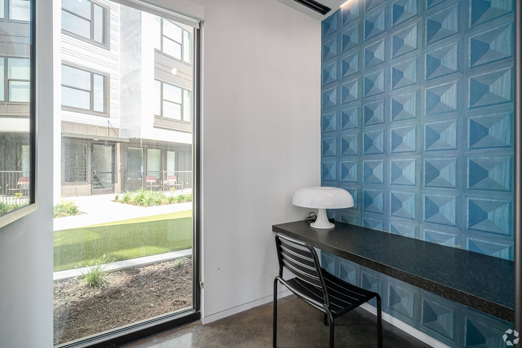 a desk with a chair in a room with a window