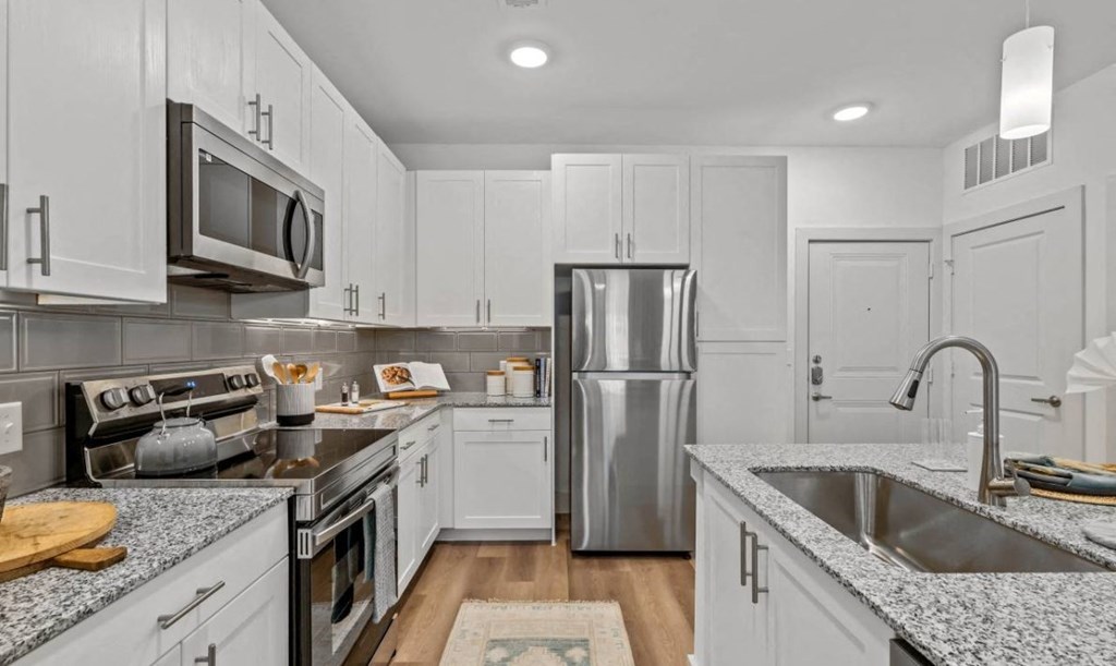 a kitchen with white cabinets and stainless steel appliances