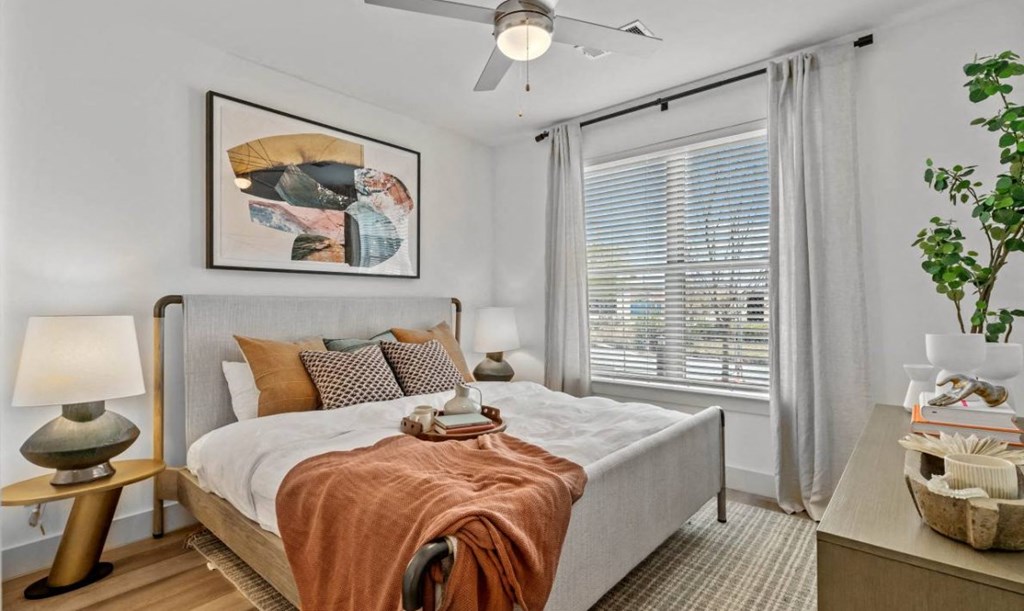 a bedroom with a bed and a ceiling fan