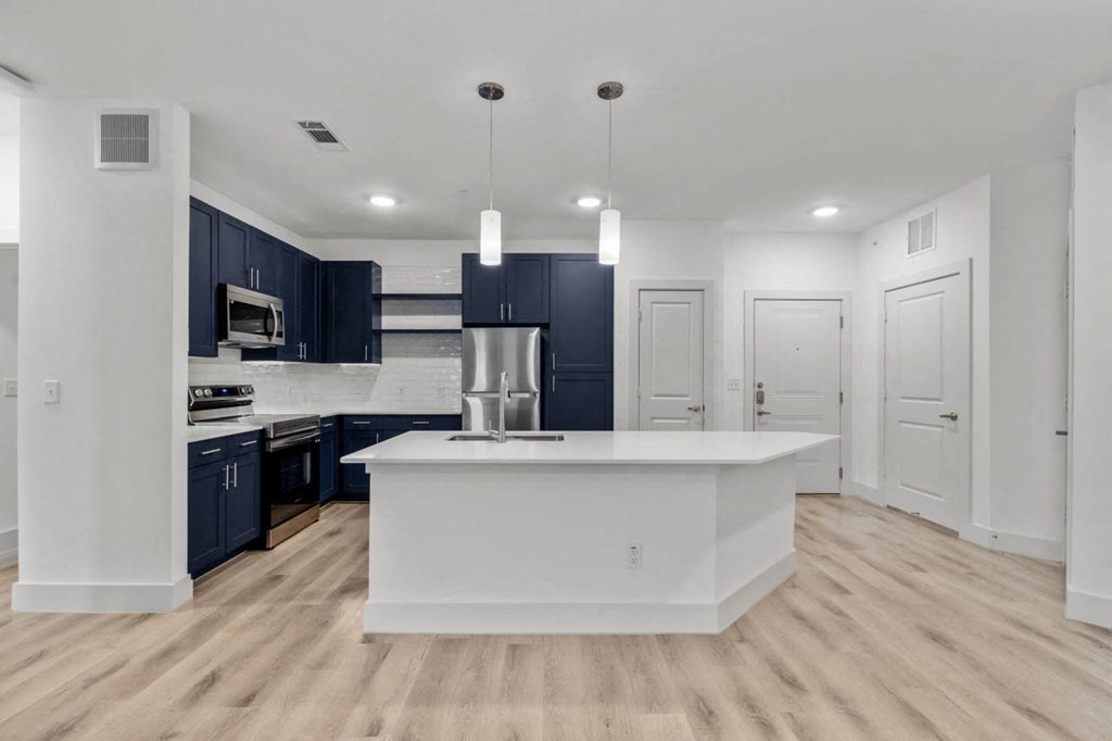 a white kitchen with a large island and black cabinets