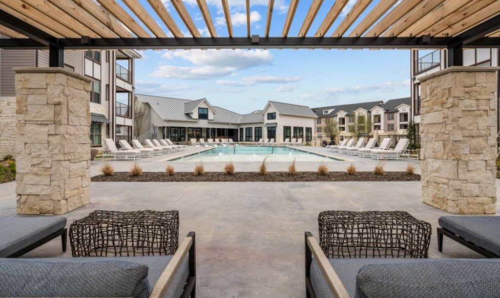 a pool with lounge chairs and a building with a pool