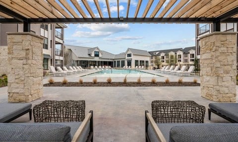 a pool with lounge chairs and a building with a pool