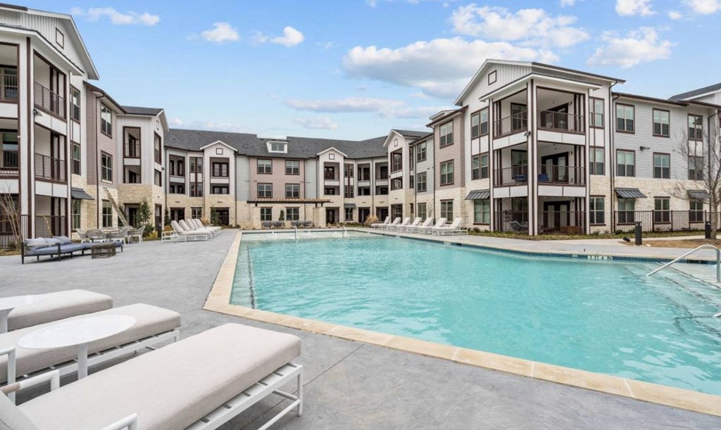 an empty pool with an apartment building in the background