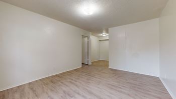 A room with a light brown floor and white walls.