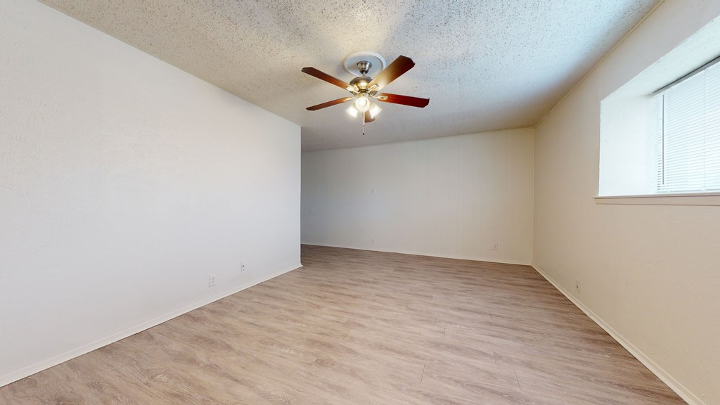 A room with a ceiling fan and light fixture.