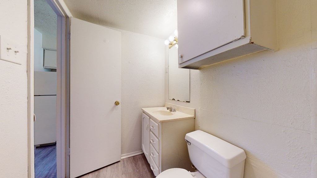 A white toilet sits next to a sink in a small bathroom.