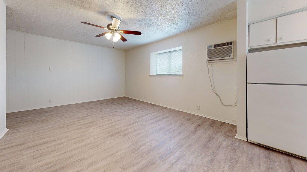 A room with a ceiling fan and a window.