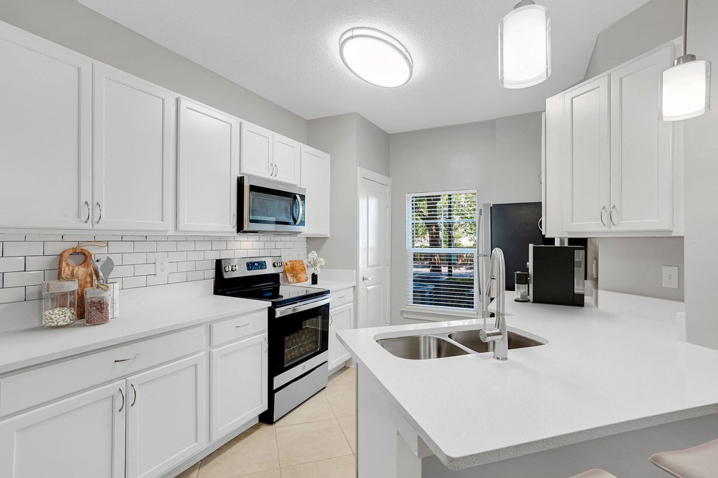a large kitchen with white cabinets and a sink