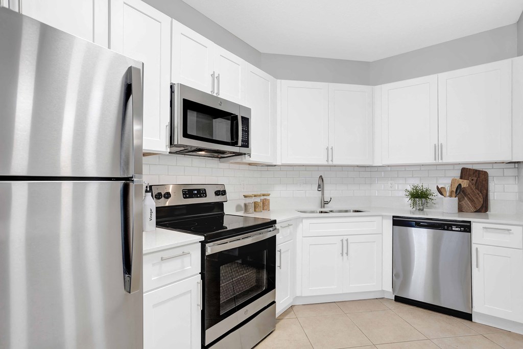 a kitchen with stainless steel appliances and white cabinets
