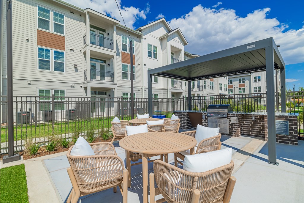 A patio with a table and chairs is in front of a building.