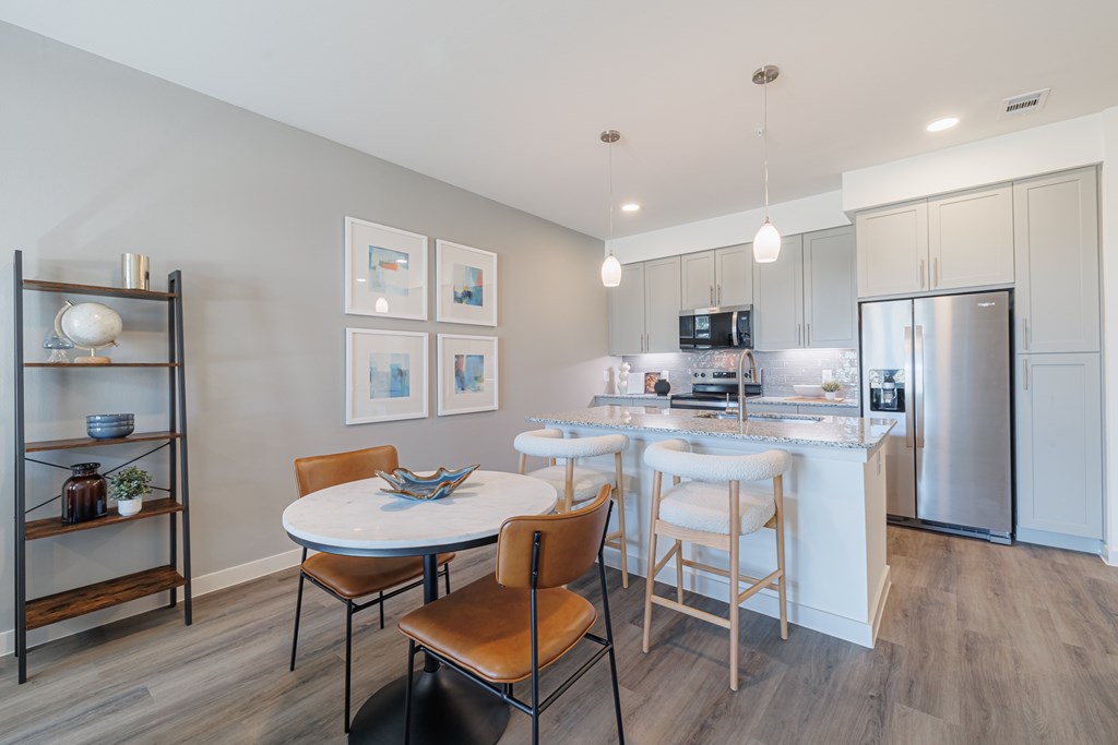 A modern kitchen with a dining table and chairs.