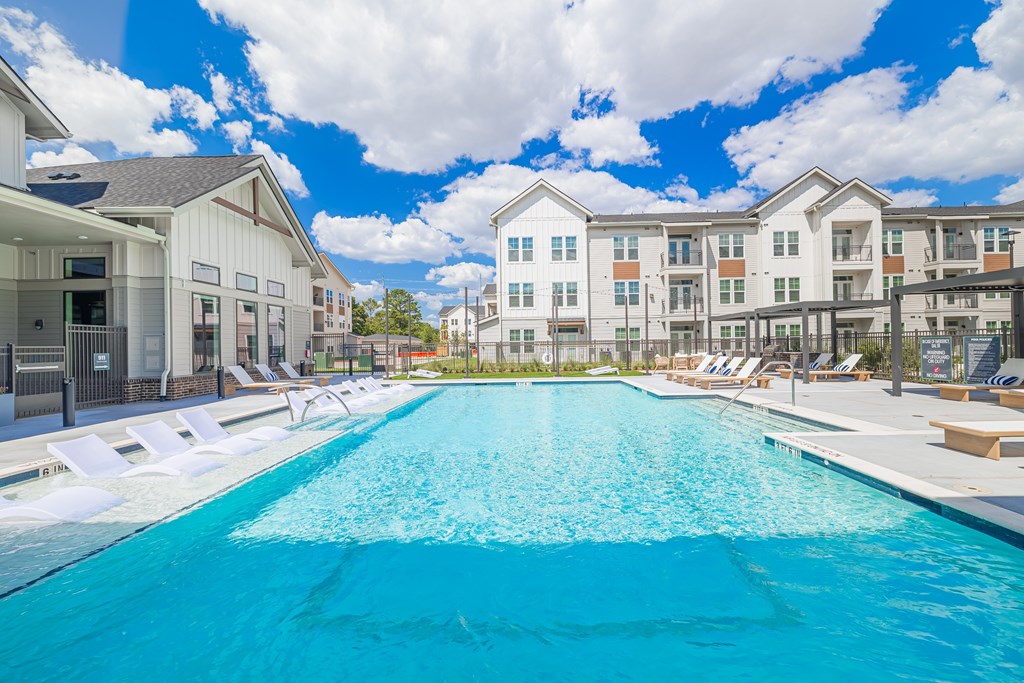 A large swimming pool in front of apartment buildings.