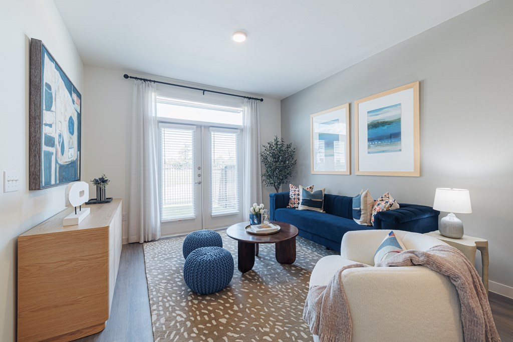 A living room with a blue couch and a wooden cabinet.