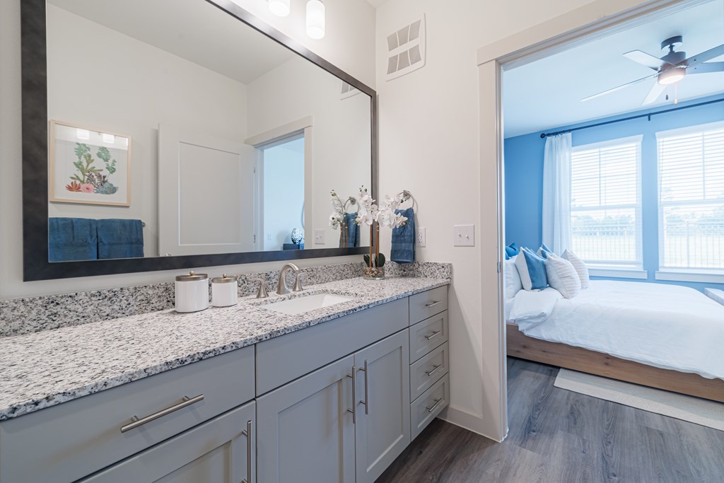 A bathroom with a large mirror and a sink.
