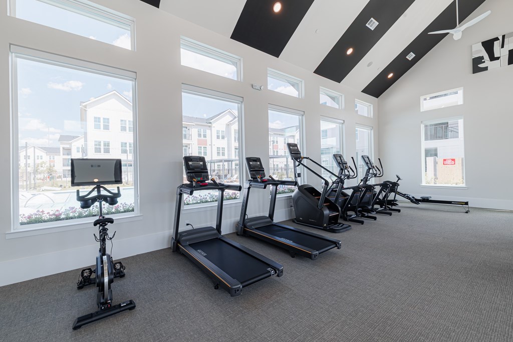 A gym with treadmills, exercise bikes and a rowing machine.