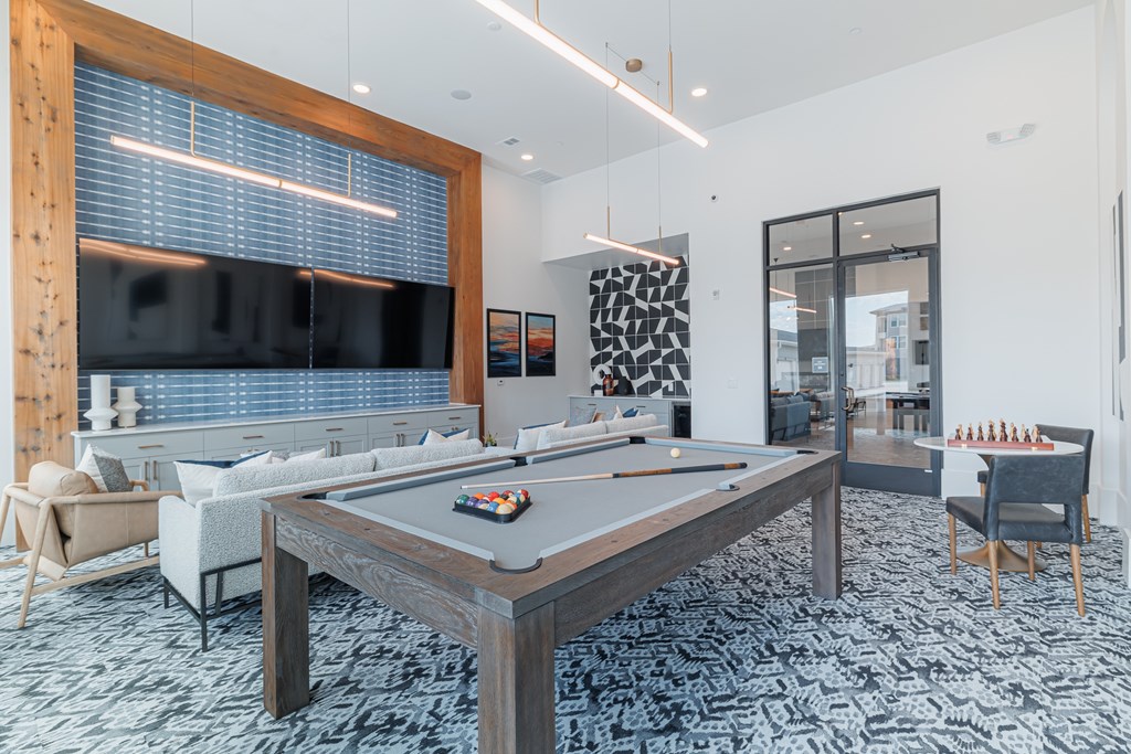 A room with a pool table and a television.