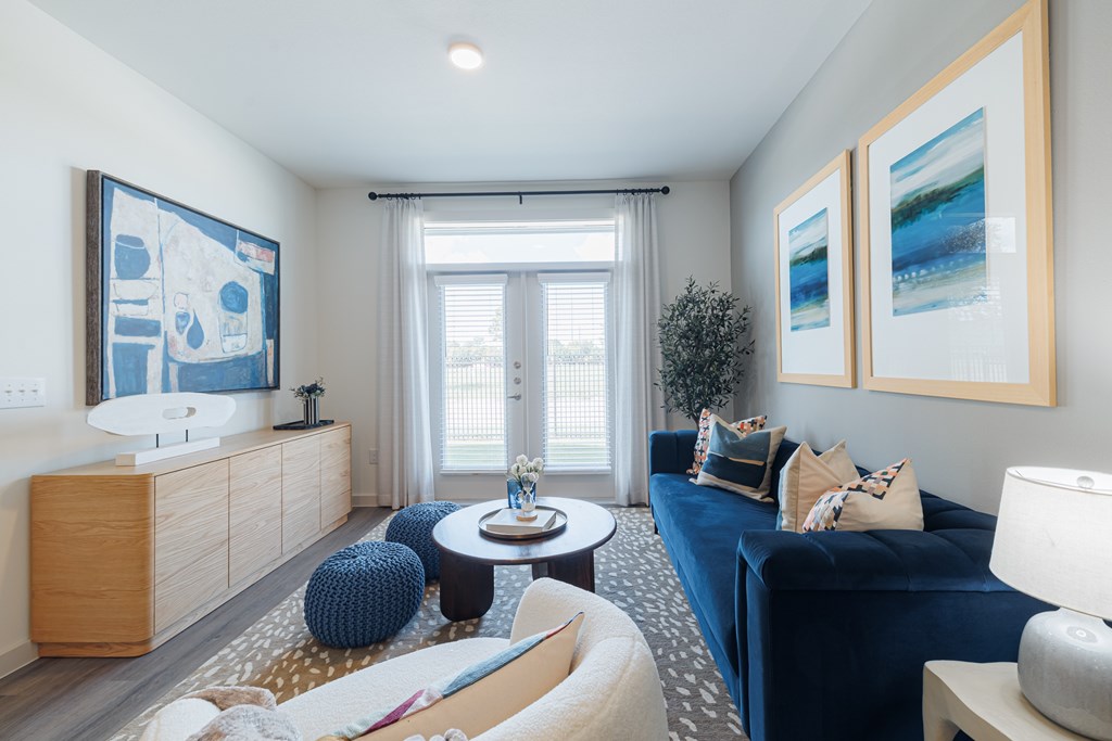 A living room with a blue couch and a wooden cabinet.