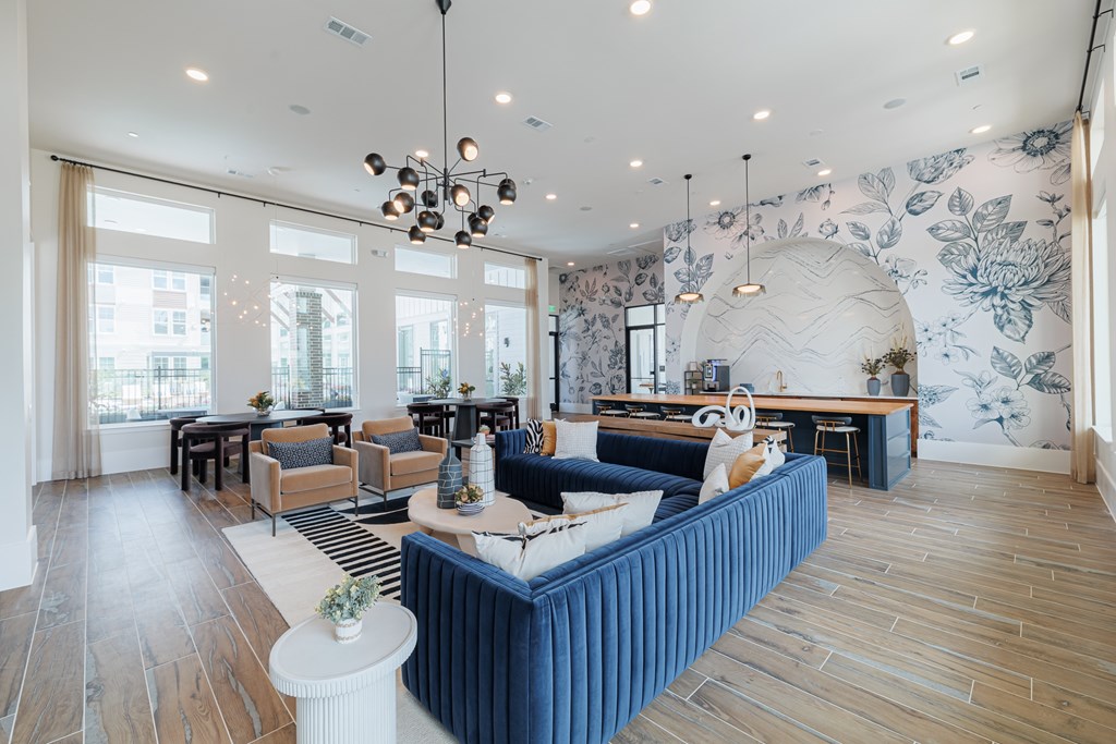 A living room with a blue sofa and wooden floors.