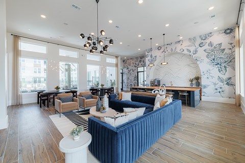 A living room with a blue sofa and wooden floors.