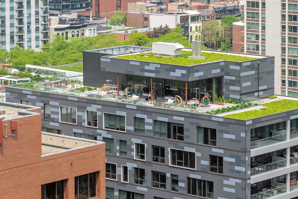 A modern building with a green roof sits atop a cityscape.