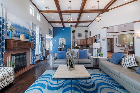 A living room with a fireplace and a blue rug.