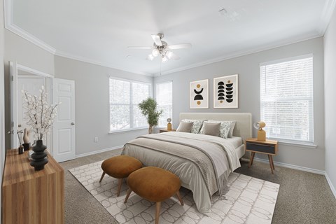 A bedroom with a large bed, a wooden table, and a ceiling fan.