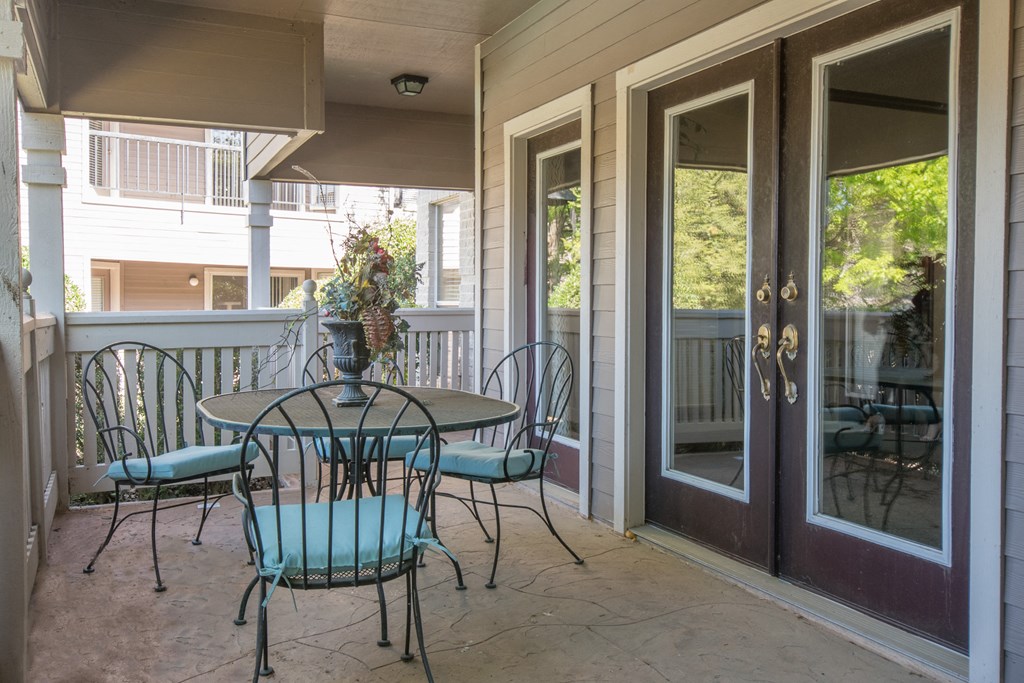 a patio with a table and chairs in front of a door