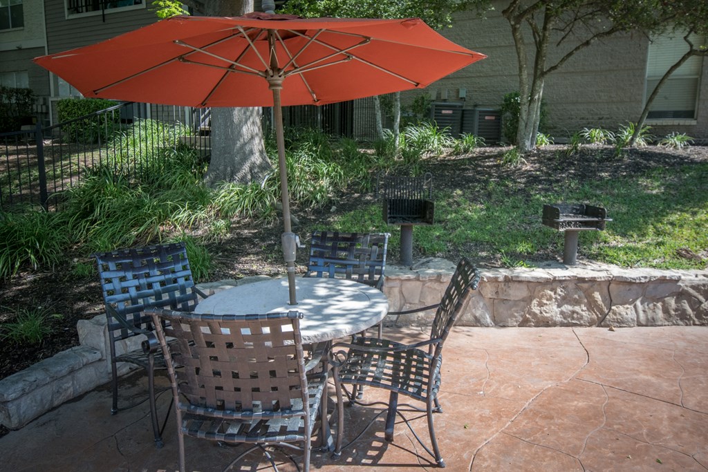 a patio with a table and chairs and an umbrella