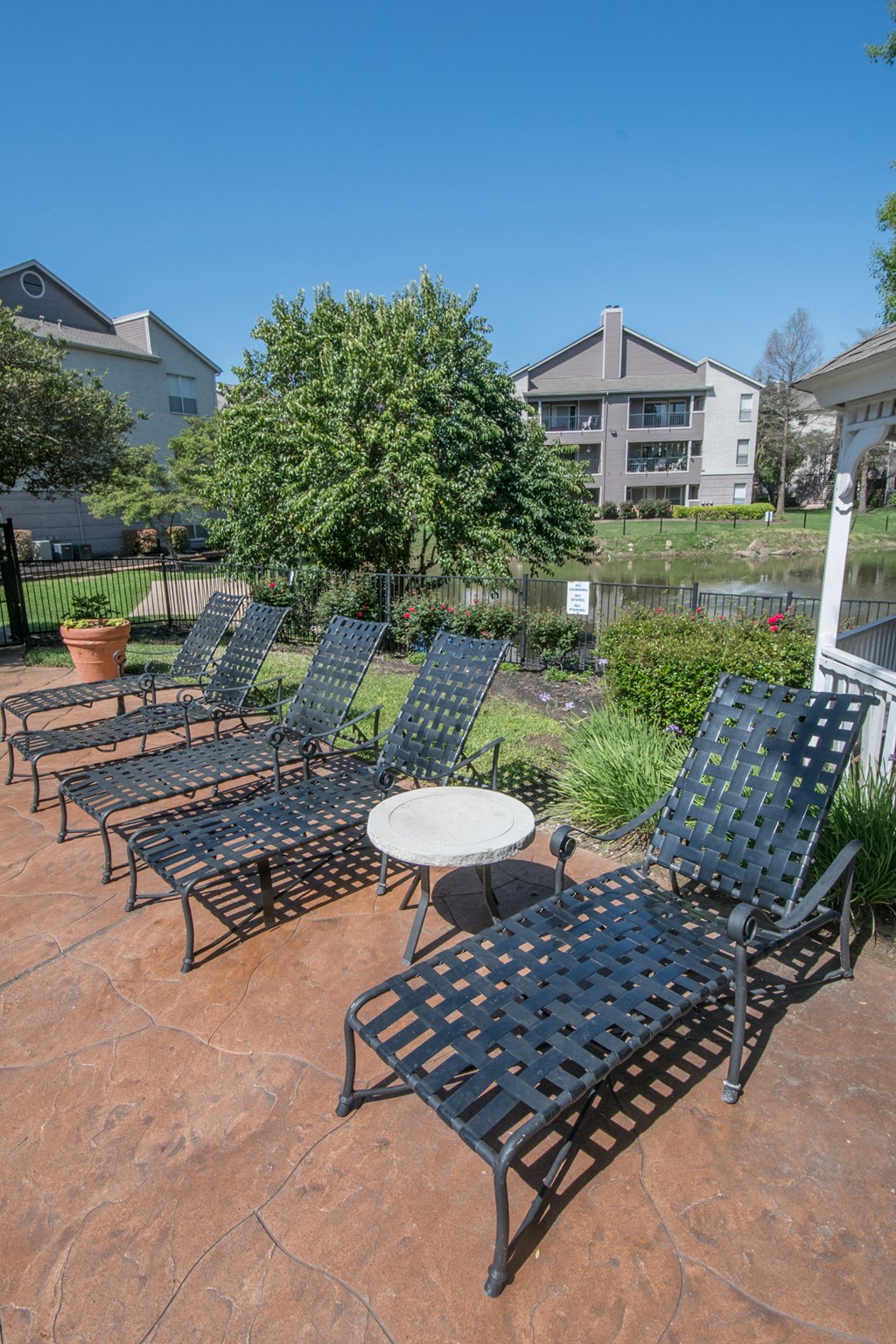 a patio with lounge chairs and a table