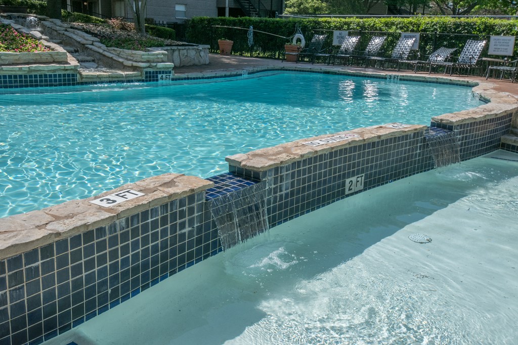a swimming pool with a tiled wall and steps leading into the water