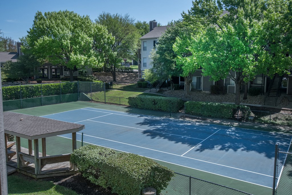 a tennis court at the whispering winds apartments in pearland, tx