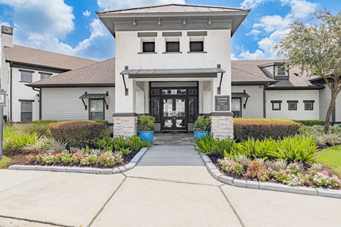 The front of a white building with a black awning and a black door.