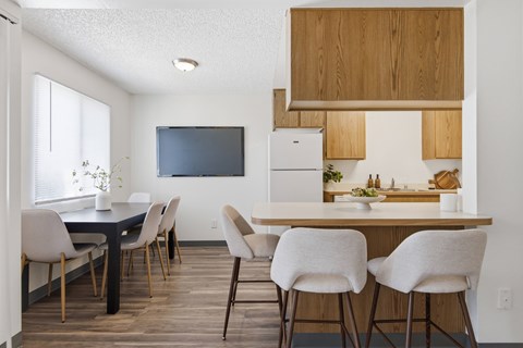 A modern kitchen with a dining table and chairs.
