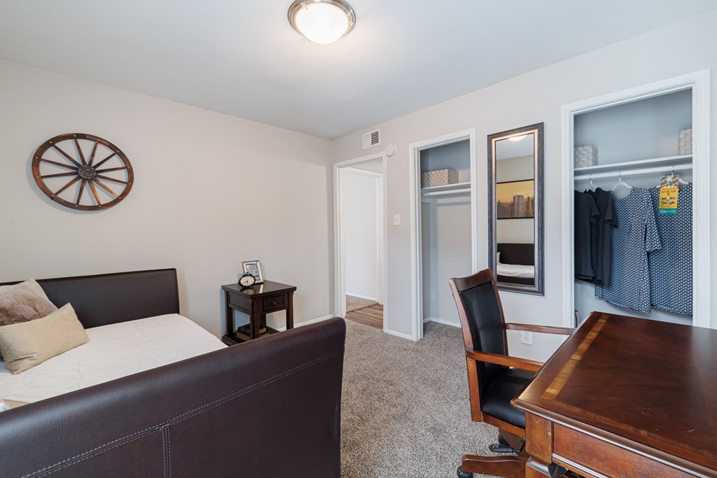 a living room with a couch and a desk and a closet