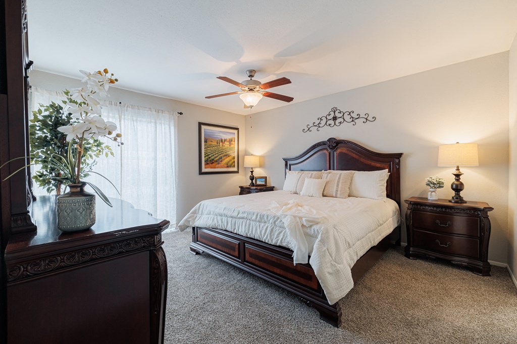 a bedroom with a large bed and a ceiling fan