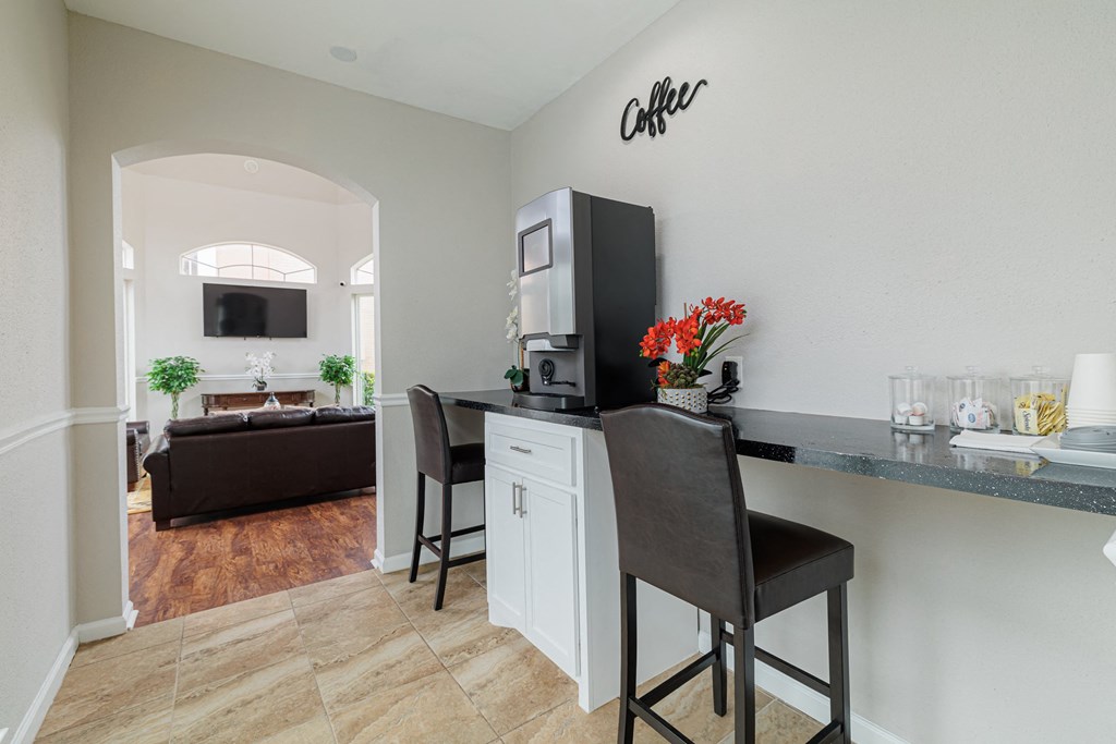 a living room with a counter with two chairs and a couch
