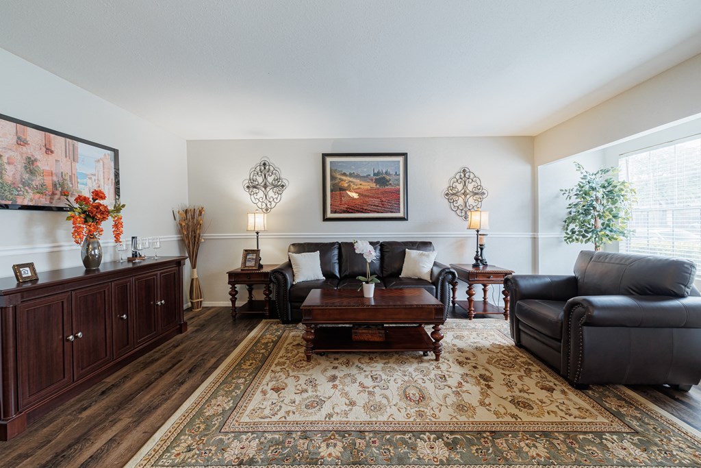a living room with leather furniture and a rug