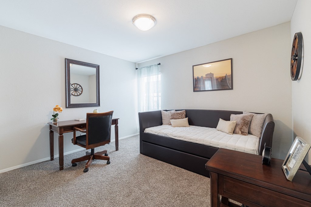 a bedroom with a bed and a desk with a chair