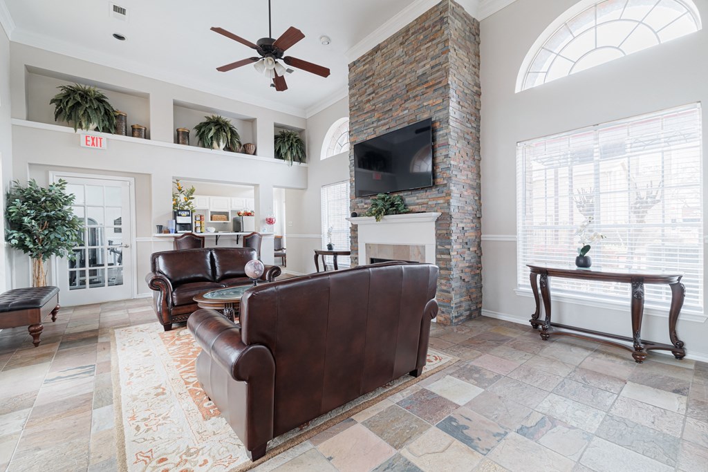 a living room with leather furniture and a brick fireplace
