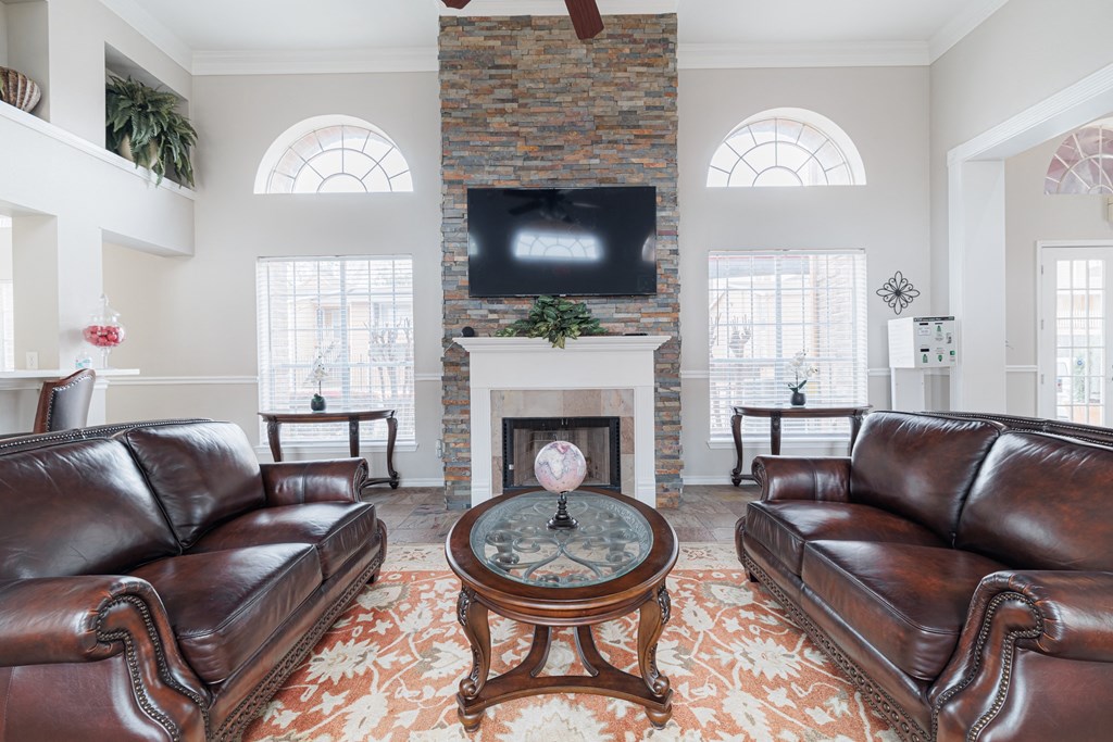 a living room with leather couches and a fireplace