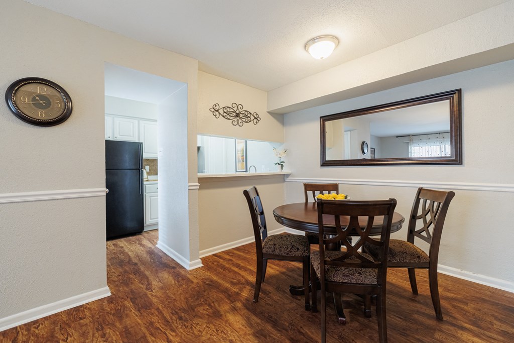 a dining room with a table and chairs and a mirror