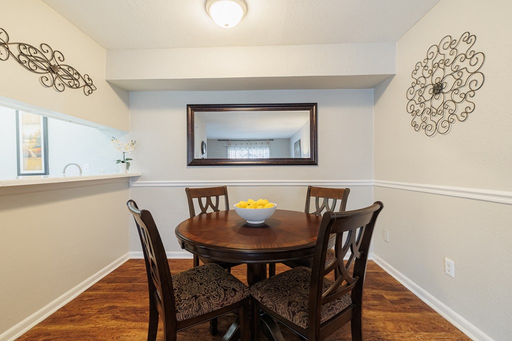 a dining room with a table and chairs and a mirror