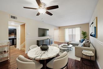 a living room with a ceiling fan and a large window