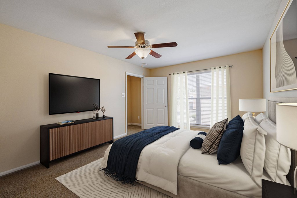 a bedroom with a large bed and a ceiling fan